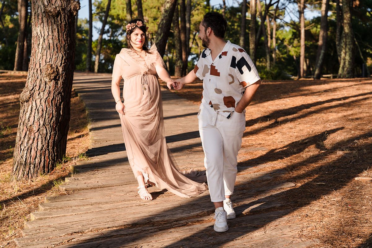 Séverine et Maxime en promenade sous les pins, capturés par Michael Jamet, photographe grossesse en Gironde