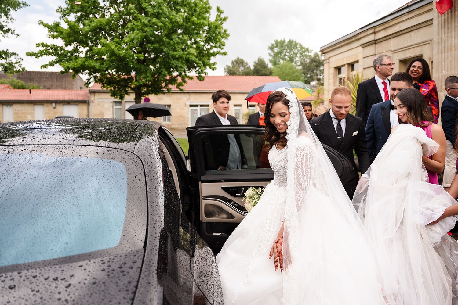 Photographie de Safia qui entre dans la voiture des mariés