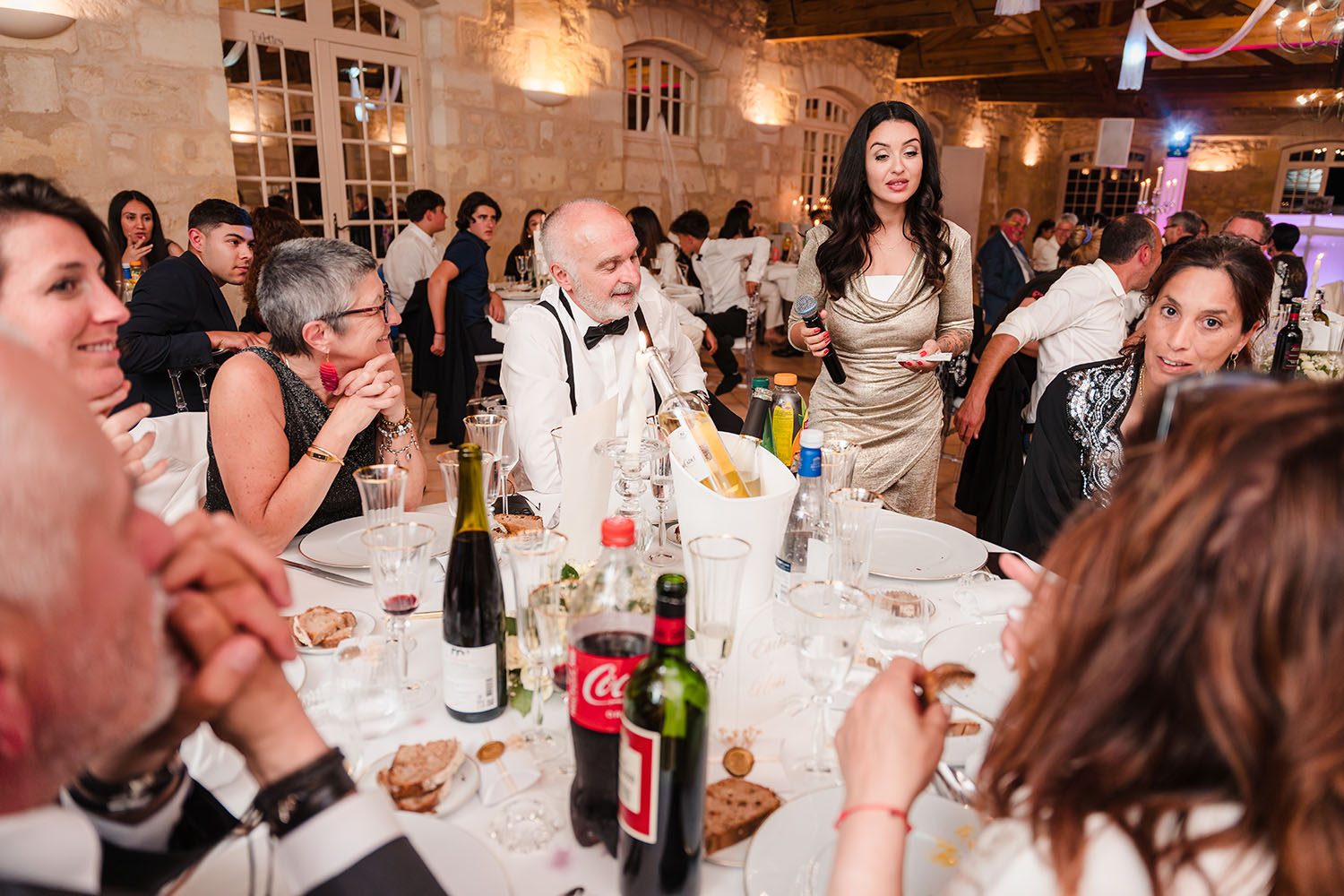 Photographie des invités attablés qui participent à une animation pendant la soirée de mariage