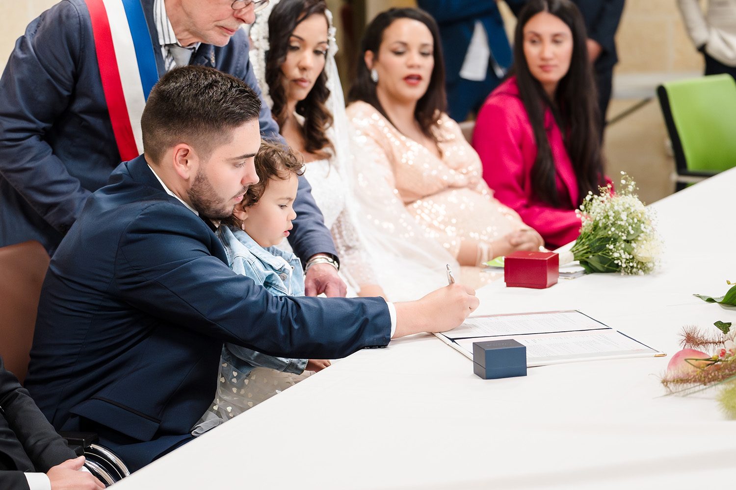 Photographie d'Antoine qui signe le registre de mariage à la mairie.