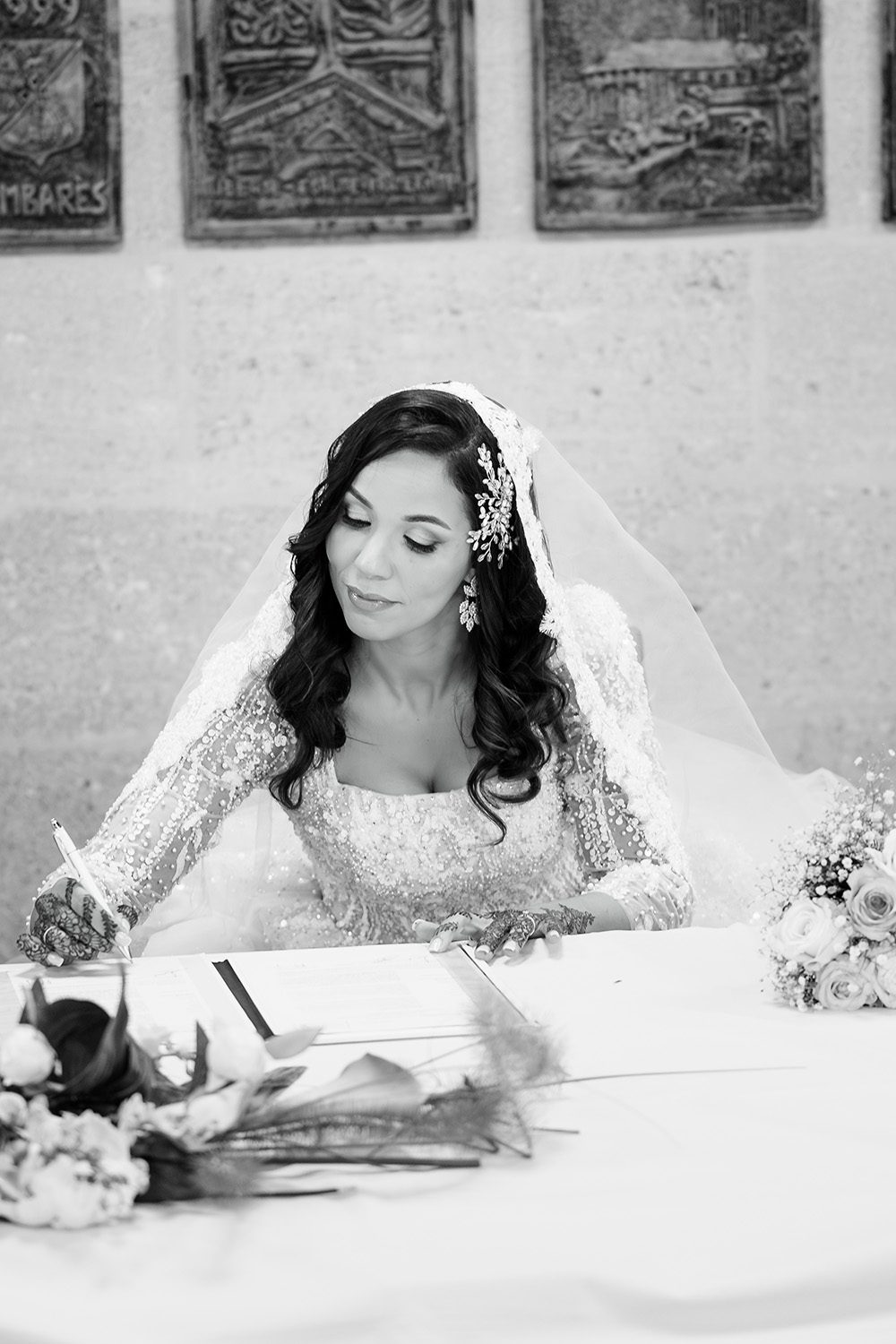 Photographie de Safia qui signe le registre de mariage à la mairie.